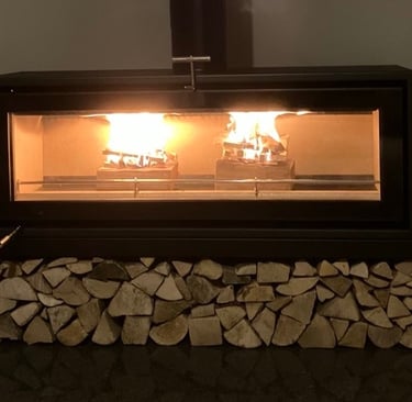 A log burning stove with stacked Ready To Burn kiln dried hardwood logs