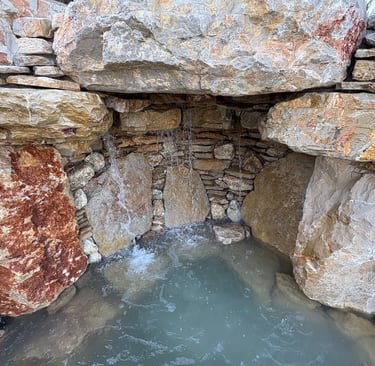 Handcrafted grotto cave under waterfall with limestone & quartzite for natural pool | Aqua Vitae