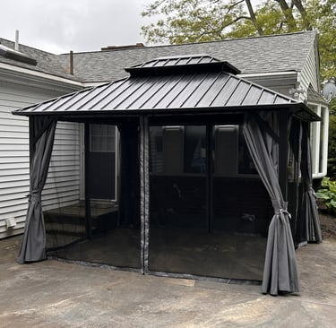 A 10 x 12 gazebo assembled with mosquito netting and privacy curtains