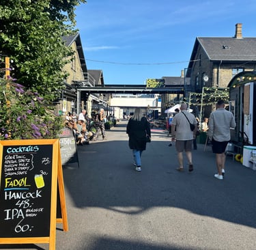 three people walking mindfully under a sign in a Copenhagen