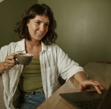 a woman sitting at a desk with a cup of coffee