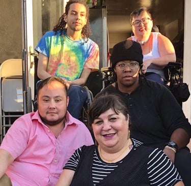 Photo of Stacey with members of DJCC sitting on stairs.