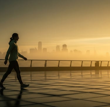 Pessoa caminhando ao amanhecer com céu dourado, simbolizando disciplina matinal, foco e saúde