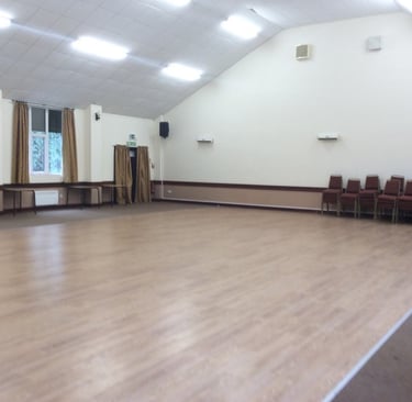 a room with a large wooden floor and a large window