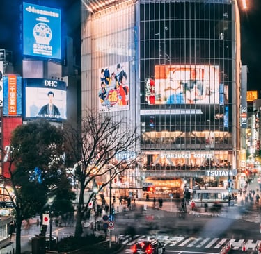 View of Shibuya Crossing at night with neon lights and pedestrians – iconic Tokyo travel guide image