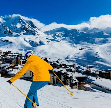 Lifestyle photograph of skiers enjoying a wide, sunny slope in Val Thorens, Europe's highest ski res