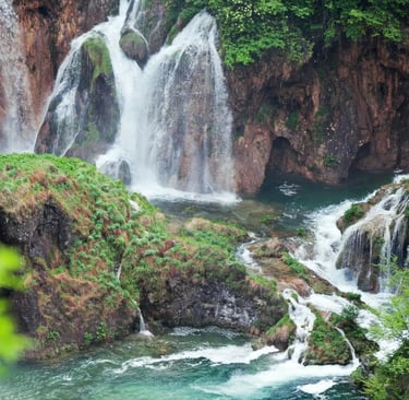 Plitvice Lakes National Park waterfalls cascading into turquoise pools surrounded by forest.