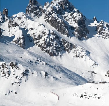 Dramatic close-up of rugged snow-covered mountain peaks under a clear winter sky.
