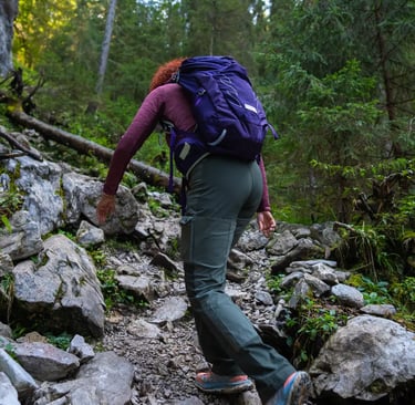 Hiker equipped with helmet and harness on exposed section of Sentiero Bonacossa trail.