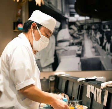 Japanese sushi chef (itamae) in a white uniform and chef's hat