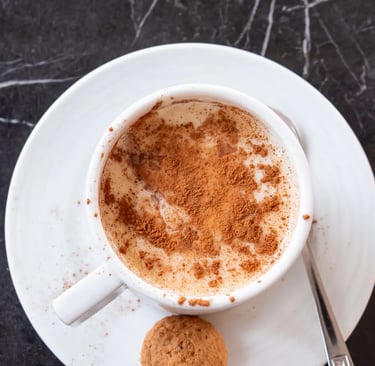 a cup of coffee with a cookie on top of it
