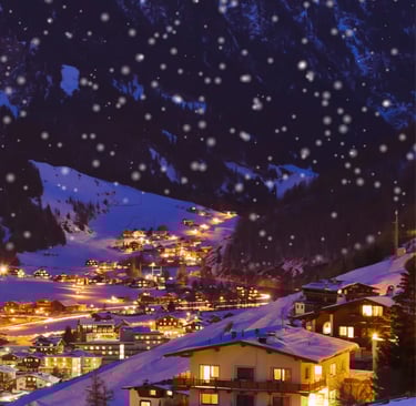 Starry night sky over the Austrian Alps. A charming ski resort village twinkling with lights in the