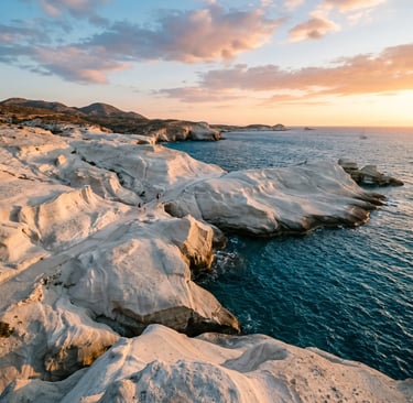 Sarakiniko white volcanic rock formations meeting turquoise Aegean Sea in Milos at sunset