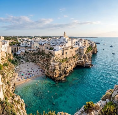 Panoramic view of Polignano a Mare white houses on limestone cliffs above turquoise Adriatic Sea