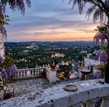 Cisternino panoramic terrace at sunset with Primitivo wine glass and Valle d'Itria view framed by wisteria