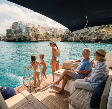 Family with kids and grandparents enjoying yacht deck with Polignano a Mare old town backdrop