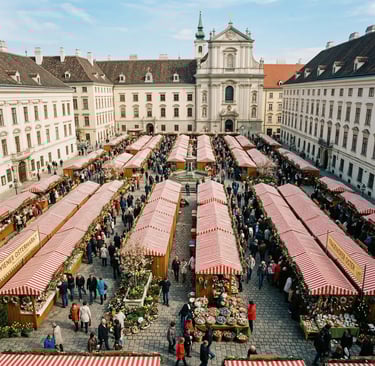 Aerial view of Vienna Easter market with red-striped stalls in a historic baroque square
