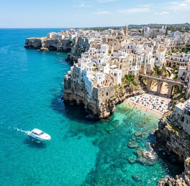 Aerial view of Polignano a Mare white cliffs turquoise sea and private boat near Lama Monachile