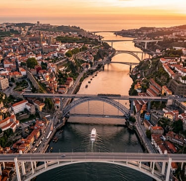 Aerial drone view of Porto six bridges over Douro River with yacht at golden hour