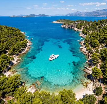 Drone shot of crystal clear turquoise bay with white private boat anchored inside