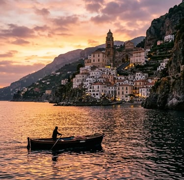 Amalfi village and cathedral seen from the sea at sunset with small boat silhouette