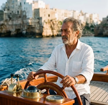 Italian captain in white linen shirt steering luxury gozzo boat near Polignano a Mare cliffs