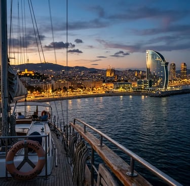 Barcelona illuminated skyline seen from sailing yacht at dusk with W Hotel and coastline