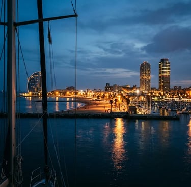 Barcelona waterfront and W Hotel at blue hour seen from a sailing yacht at sea
