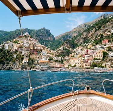 Approaching Positano by boat under striped canopy with colorful hillside village ahead