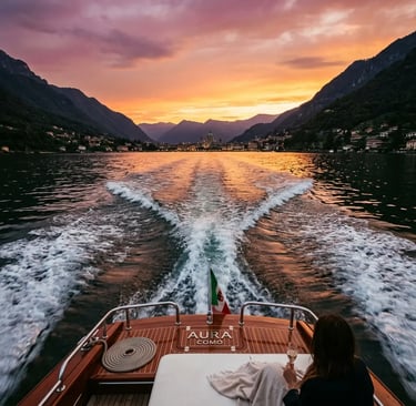 Stern view of luxury wooden boat cruising Lake Como at sunset with mountain silhouettes Italy