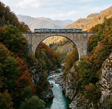 Blue Centovalli Express train on stone arch bridge above river gorge with colorful autumn forest