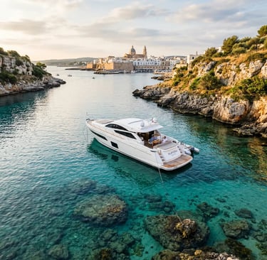Aerial view of white private yacht Aurora anchored in turquoise cove near Monopoli old town