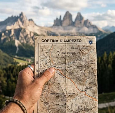 Hand holding Cortina d'Ampezzo map with Tre Cime peaks blurred in background