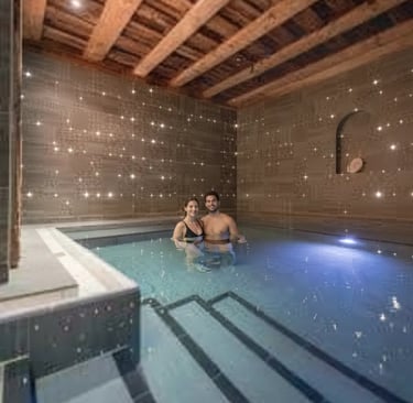 A couple relaxing in a dimly lit, atmospheric indoor thermal pool at Aqua Dome, a premier luxury wel