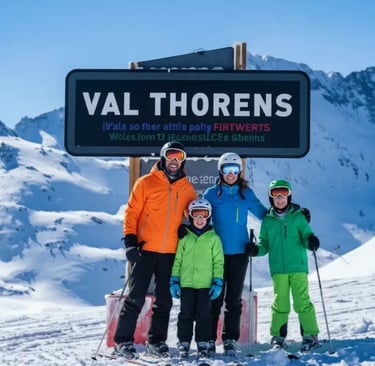 A family of four posing in front of a Val Thorens mountain sign on a sunny day.