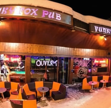 The exterior entrance of Funky Fox Pub in Courchevel at night, featuring neon signs and cozy outdoor