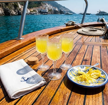 Three limoncello glasses and lemon zest plate on teak deck of Capri boat tour from Sorrento