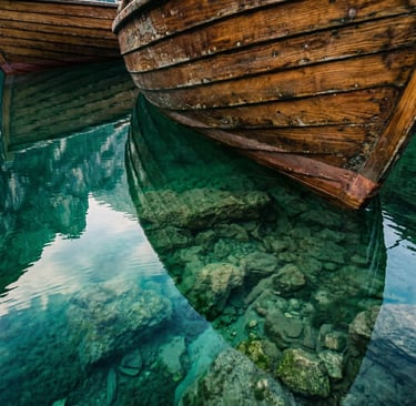 Weathered wooden rowboat hull over crystal-clear turquoise water at Lake Braies