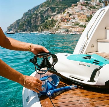 Hands holding snorkel masks beside Sea Scooter on yacht swim platform near Positano