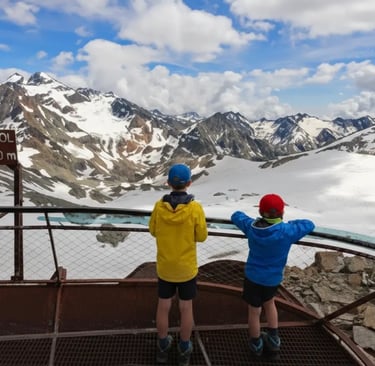 Two kids at Top of Tyrol 3210m mountain viewpoint, Stubai Glacier Alps.