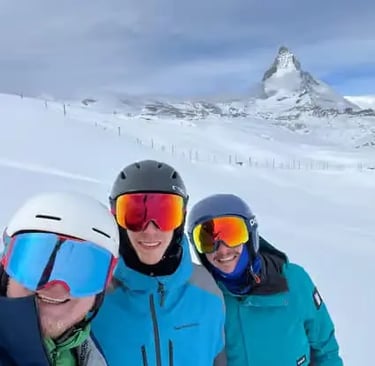 Group of friends taking a selfie with the iconic Matterhorn mountain background during a guided ski 