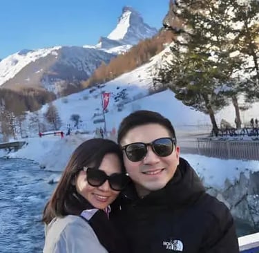 Happy couple taking a photo with the iconic Matterhorn backdrop while exploring Zermatt and hearing 