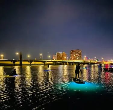 Atmospheric night kayaking and paddleboarding tour in Florida, paddling through calm waters with glo