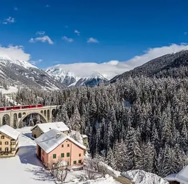 Bernina Express crossing a stone viaduct over a snowy village