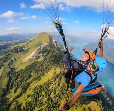 High altitude summer tandem paragliding flight above green Swiss Alps and lakes
