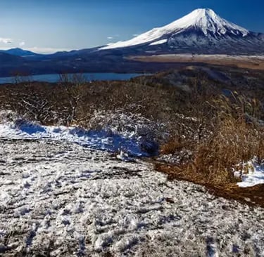 Winter hiking trail near Mt. Fuji with patchy snow on the ground and clear blue skies.
