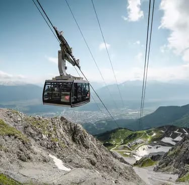 A modern Nordkette cable car cabin ascending the rugged mountain cliffs with a breathtaking view