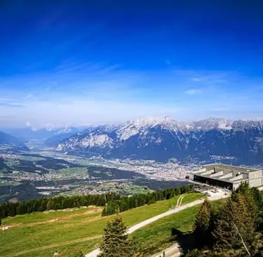 Hiking path by a mountain hut with panoramic views of the Austrian Alps.