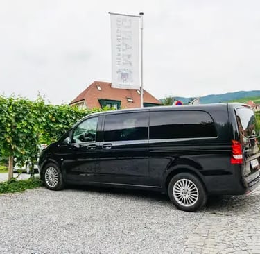 A sleek black Mercedes van parked by a vineyard for a private Wachau Valley tour.