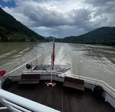 Scenic view from the back of a boat cruising the Danube River through the Austrian Alps.
